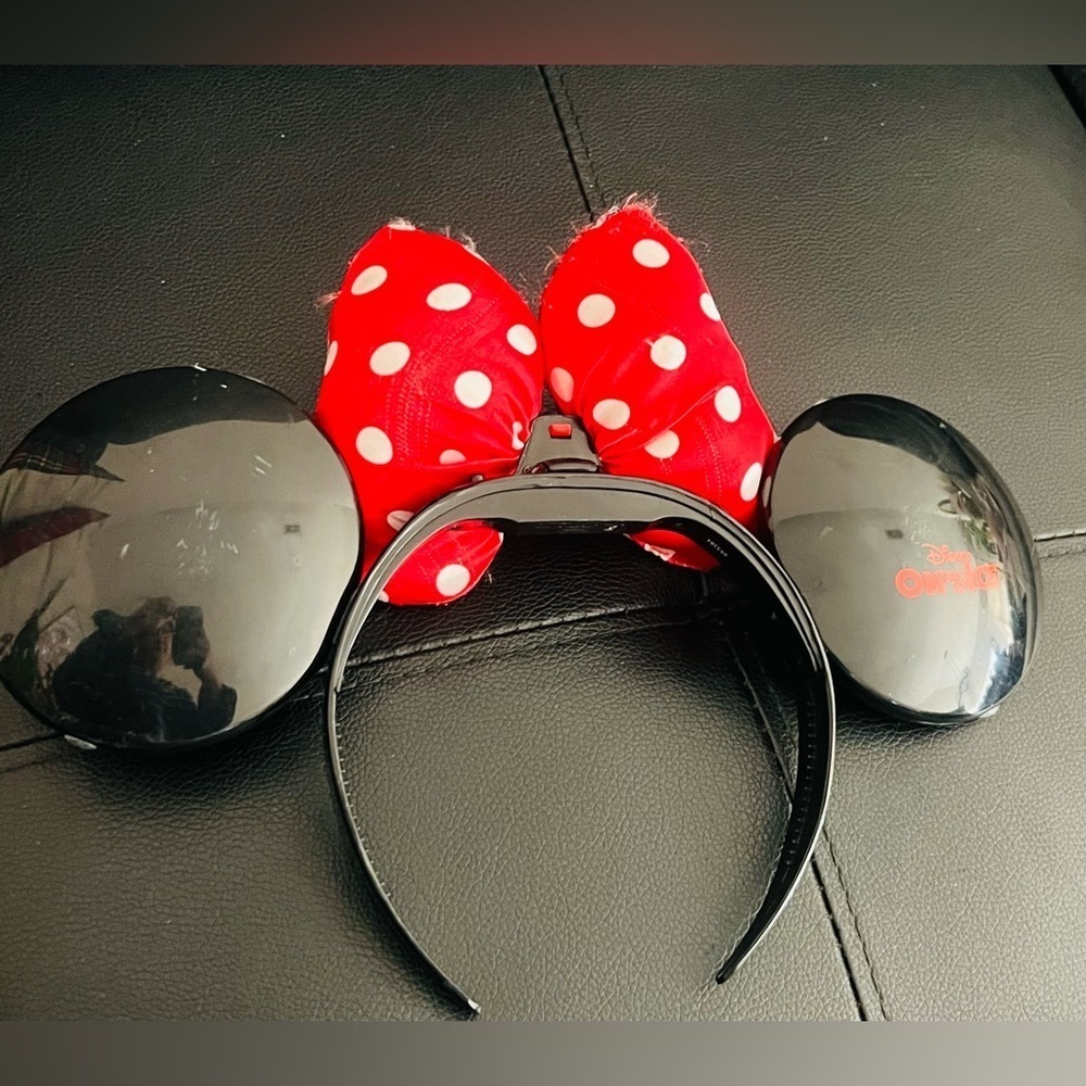 Minnie Mouse ear headband with a red and white polka dot bow.